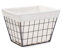 a white basket with black wire on the bottom and sides, it is sitting on a white surface