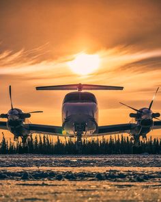 an airplane is sitting on the runway at sunset