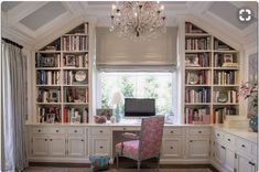 a room with a desk, bookshelf and chandelier