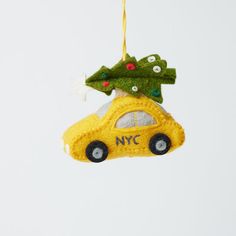 a christmas ornament hanging from the ceiling with a yellow car and tree on top