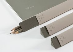 three pencils sitting next to each other on a white surface