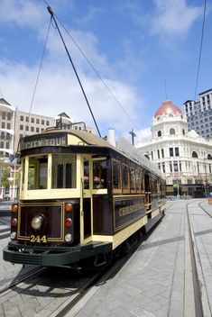 a trolley car is traveling down the street