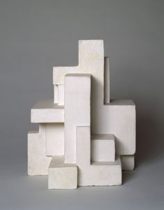 a white sculpture sitting on top of a gray floor next to a pile of blocks