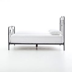 a metal bed frame with white sheets and pillows on it, against a white background