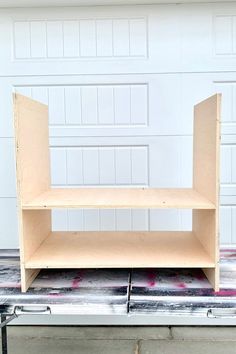 a shelf sitting in front of a garage door on top of a piece of cardboard