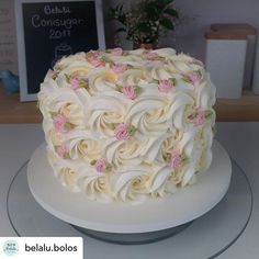 a cake with white frosting and pink flowers on it