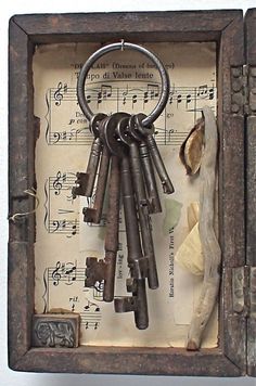 a bunch of keys that are inside of a wooden box with sheet music on it