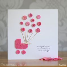 a card with pink buttons and a baby carriage