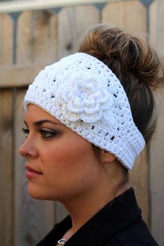 a woman wearing a white crochet headband with a flower on it's side