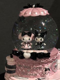 there is a snow globe with two cats in it on top of a cake that says hello kitty