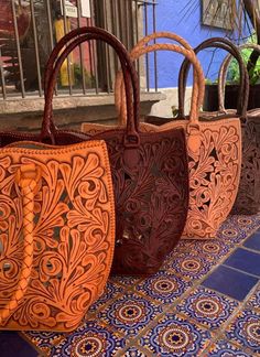 Elevate your style with the Genuine Hand-Tooled Leather Tote, "IBIZA" by ALLE! Hand-tooled from premium full-grain hide, this tote is adorned with intricate leaf and honeycomb designs. The exquisite hand-stitched details on the sides add a touch of sophistication. Perfect for work or daily use, this tote boasts a spacious interior and convenient pockets. Get ready to experience luxury in every aspect with the Ibiza tote! Made from Full-grain leather, each bag varies in shading due to the thickne New Dress Collection, Color Gifts, Tooled Leather Handbags, Purse Outfit, Womens Suede Boots, Tooled Leather Purse, Unique Handbags, Large Leather Tote, Brown Leather Bag