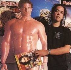 two men standing next to each other in front of a poster