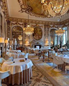 an ornately decorated dining room with chandeliers and white linens on the tables