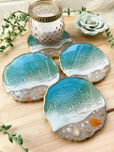 three blue and white plates sitting on top of a wooden table next to a candle