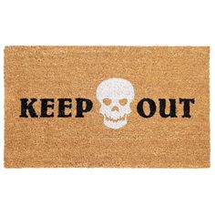 a door mat that says keep out with a skull on it