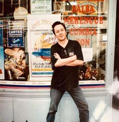 a man standing in front of a store with his arms crossed