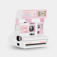 a pink polaroid camera sitting on top of a white box with its door open