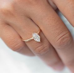 a woman's hand with a diamond ring on top of her finger and an engagement band