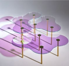 three glass tables sitting on top of each other with wooden sticks sticking out of them