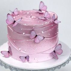 there is a pink cake with butterflies on it