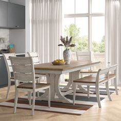 a dining room table and chairs in front of a window