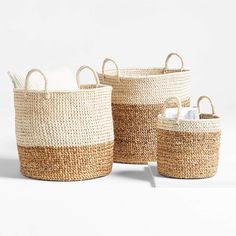 three woven baskets with handles, one in white and the other in natural color straw