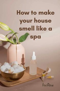 a pink vase filled with flowers next to a small bottle of soap on a wooden tray