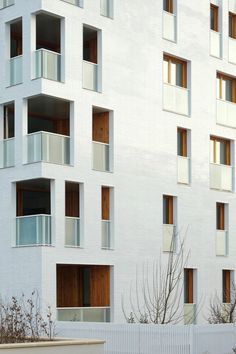 a tall white building with balconies and windows