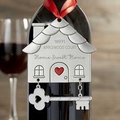 a bottle of wine with a house shaped key attached to it