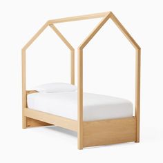 a bed with a wooden frame and white sheets on top of it, in the shape of a house