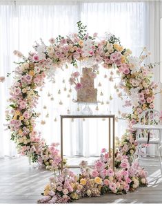 the wedding cake is surrounded by pink and yellow flowers on top of a white table