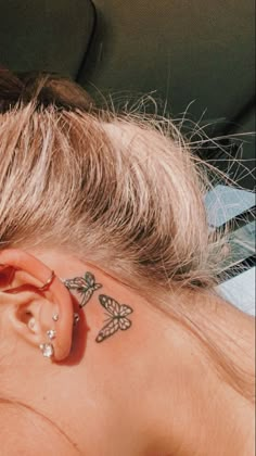 a woman with a butterfly tattoo on her left side behind the ear is laying down