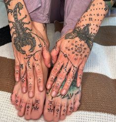 two people with tattoos on their hands are holding each other's palms and fingers