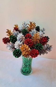 a vase filled with lots of different colored pine cones and snow flakes on top of a table