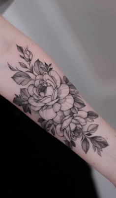 a black and white flower tattoo on the arm