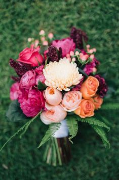 a bouquet of flowers sitting on top of a lush green field