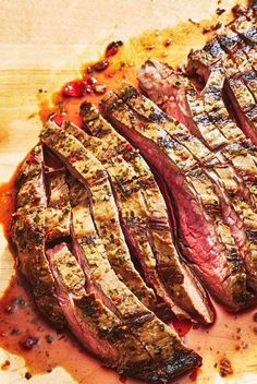 steak sliced up on a cutting board with sauce and seasoning sprinkles