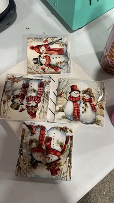 four snowmen with hats and scarfs on them are sitting next to each other