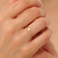 a woman's hand with a diamond ring on top of her finger and the other hand holding it