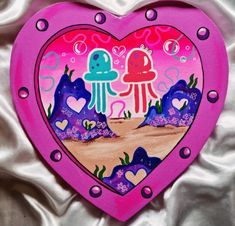 a pink heart shaped box with an octopus and jellyfish painting on it's side