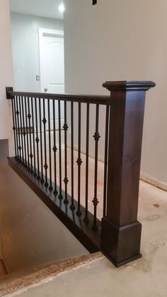 an empty room with a wooden railing and white walls