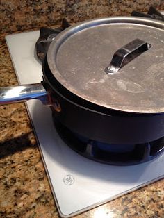 a pan sitting on top of a stove next to a spatula