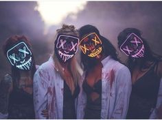 three women with neon masks on their faces