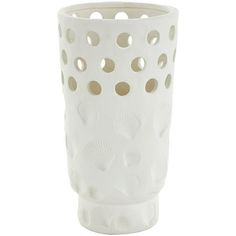 a white vase with holes in the middle and shells on it's sides, sitting against a white background