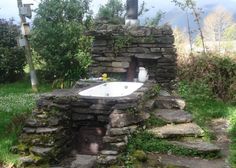 an outdoor hot tub in the middle of some rocks