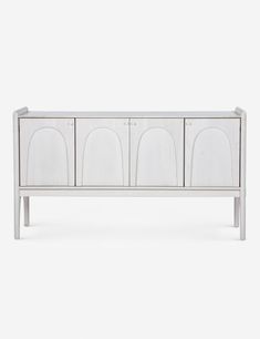 a white sideboard with four doors and three drawers on the front, against a white background