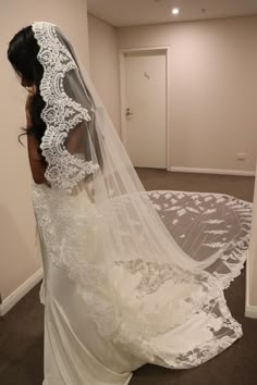 a woman in a wedding dress looking at her veil