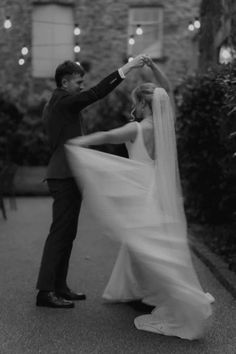 the bride and groom are dancing together outside