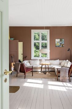 a living room filled with furniture next to a window covered in sunlight from the windows