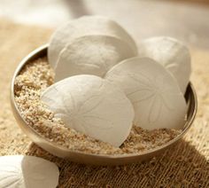 several pieces of sea salt in a metal bowl on a burlap tablecloth